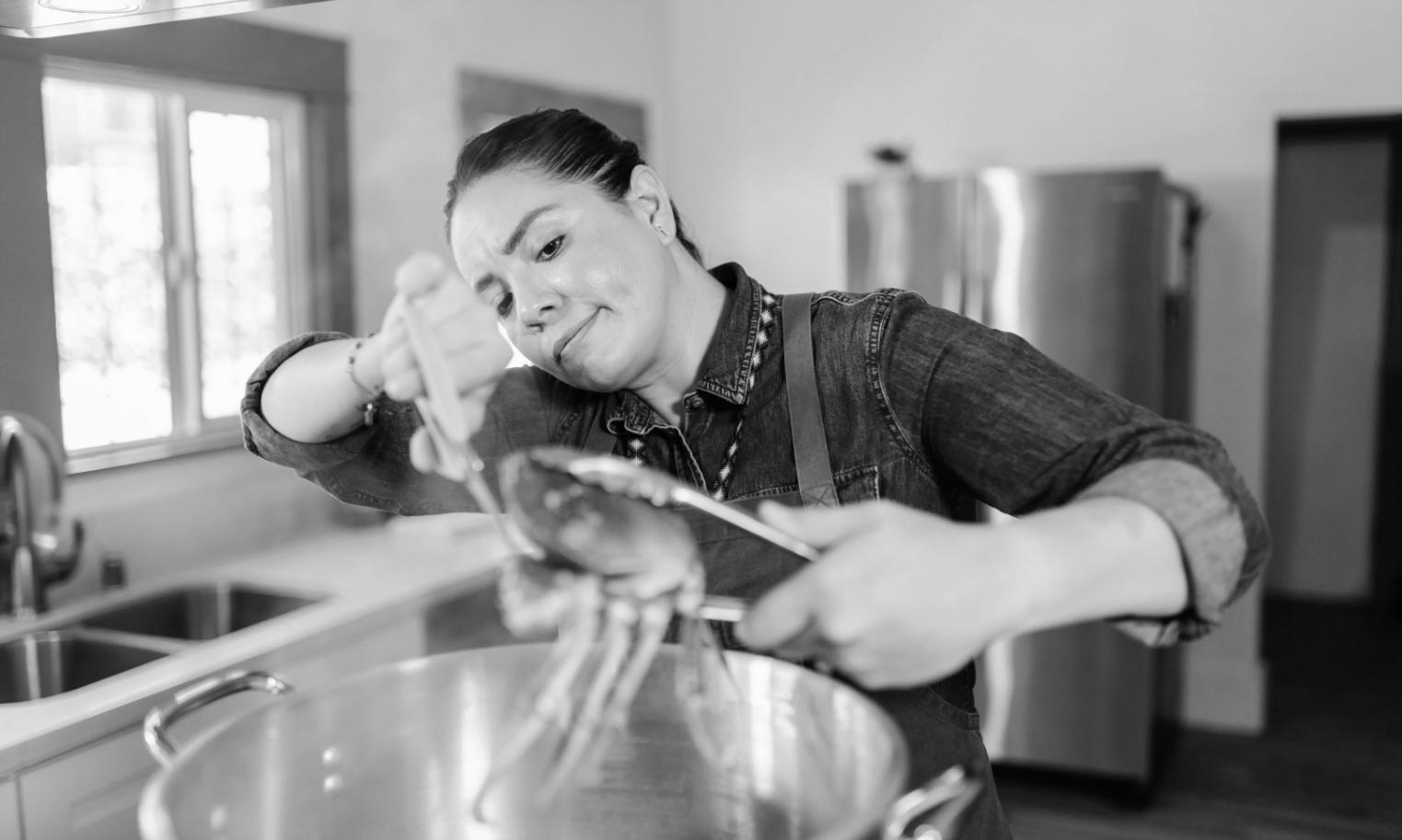Hands carefully arranging fresh ingredients on white ceramic plate demonstrating professional plating technique